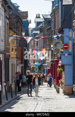 Gli amanti dello shopping nelle vecchie strade di Honfleur, Normandia, Francia con colorati bunting Foto Stock