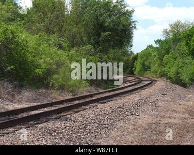 La curvatura della ferrovia via nella periferia di una città Foto Stock