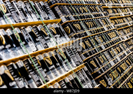 File di lattine di Guinness memorizzati e fissare con cinghie su pallet. Foto Stock