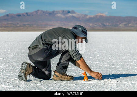 Salar de Uyuni, Uyuni, Bolivia : i turisti a piedi in bianco le saline e godere di tour in jeep attività attraverso la guida Boliviana deserto di sale Foto Stock