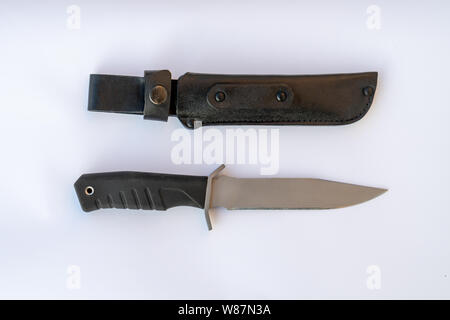 Esercito nero coltello su uno sfondo bianco. il coltello e la copertina in pelle nera di close-up. Foto Stock