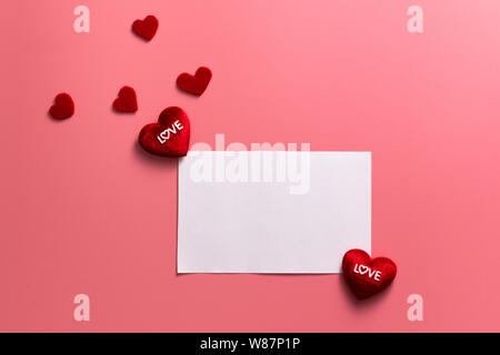 Il giorno di San Valentino concetto, cuori di rosso e bianco nota su sfondo rosa Foto Stock