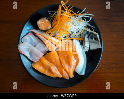 Vista superiore di vari di pesce crudo sashimi sul piatto nero, Japan food. Foto Stock