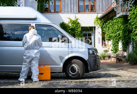 Bennigsen, Germania. 08 Ago, 2019. Un dipendente del reparto forense è in piedi in un veicolo accanto a una casa (r) in cui un uomo è detto di aver ucciso il suo partner. Il 61-anno-vecchio uomo da Bennigsen vicino Hannover composto il numero di emergenza su 08.08.2019 nel pomeriggio e ha detto alla polizia che aveva ucciso il 58-anno-vecchio. Credito: Christophe Gateau/dpa/Alamy Live News Foto Stock
