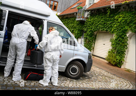 Bennigsen, Germania. 08 Ago, 2019. Due membri del team forensic sono in piedi in un veicolo accanto a una casa (r) in cui un uomo è detto di avere ucciso la sua fidanzata. Il 61-anno-vecchio uomo da Bennigsen vicino Hannover composto il numero di emergenza su 08.08.2019 nel pomeriggio e ha detto alla polizia che aveva ucciso il 58-anno-vecchio. Credito: Christophe Gateau/dpa/Alamy Live News Foto Stock