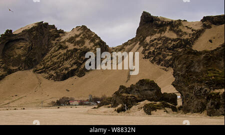 Tipico paesaggio islandese con case contro le montagne nel piccolo villaggio western Islanda Foto Stock