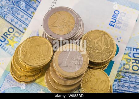 Varie monete in euro sulla parte superiore del 20 banconote in euro, Germania Foto Stock