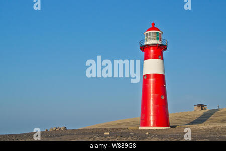 Rosso-bianco faro di fronte al mare del Nord dike. Foto Stock