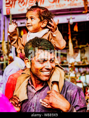 Barsana, India - 23 Febbraio 2018 - un bambino e suo padre sorriso durante Holi festival Foto Stock