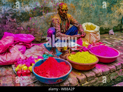 Barsana, India - 23 Febbraio 2018 - Un uomo vende la polvere di vernice per essere gettato da buontemponi durante Holi festival Foto Stock