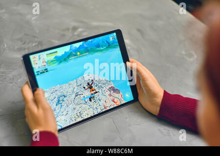 Bishkek, Kirghizistan - Gennaio 21, 2019: Donna che gioca il gioco fortnite di Epic Games company su Apple ios tablet iPad Pro. Azione di gioco Foto Stock