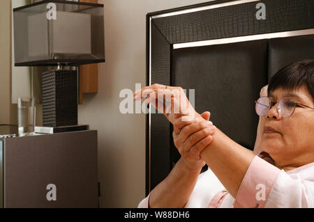 Vecchia donna affetti da polso dolore a mano, problema di salute concetto Foto Stock