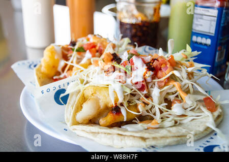 Pesci e gamberetti tacos, Baja California style tacos di pesce serviti con cavolo,pomodori,il coriandolo e una varietà di salse Foto Stock