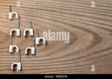 Clip per cavi in plastica bianca con rivestimento per chiodi Foto Stock