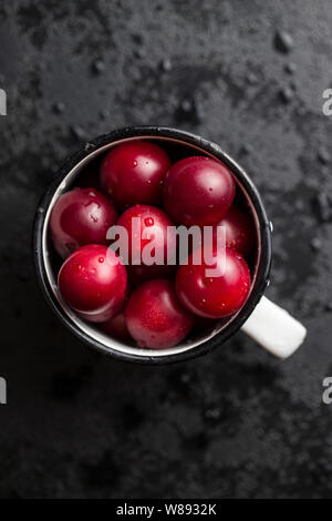 Il red cherry prugne frutta nella tazza. Vista dall'alto. Foto Stock