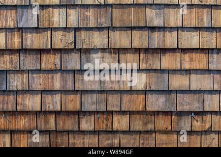 Ruvido legno sconnesso ghiaia cladding, fila di materiale legnoso di piccoli ciottoli facciata a parete. Foto Stock