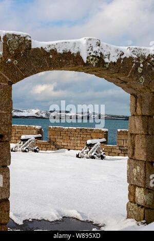 Woolpack batteria sul Garrison con vista su Santa Maria del suono di sant'Agnese, con il suo faro in disuso, isole Scilly, UK: una rara nevicata Foto Stock