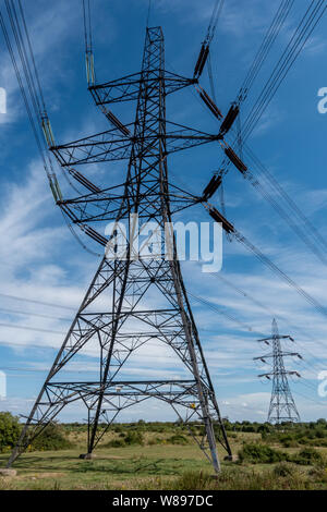 Più righe di linea aerea tralicci elettrici in campagna Foto Stock