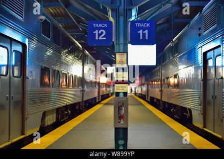 Chicago, Illinois, Stati Uniti d'America. Coppia di Metra treni pendolari attendono i passeggeri e un orario di partenza al Ogilvie Centro per il trasporto. Foto Stock