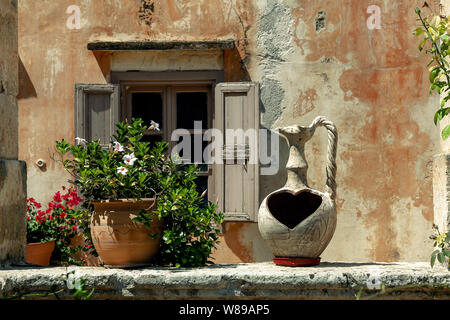 Vaso di fiori sullo sfondo di una finestra. La Grecia. Creta Foto Stock