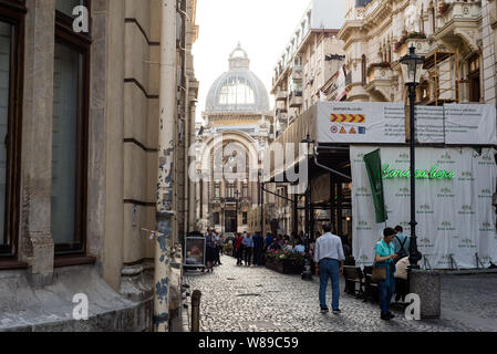 Una strada acciottolata nella città vecchia di Bucarest con un ristorante Caru' cu bere superiore locale sulla destra. Foto Stock