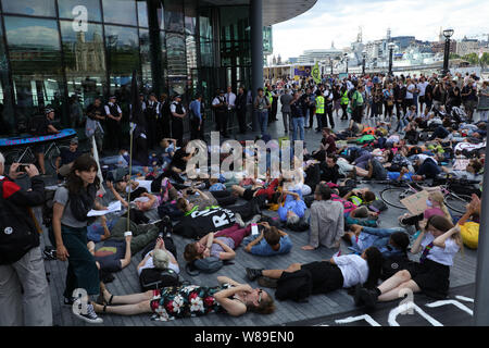 Londra, Regno Unito. Il 18 luglio 2019. Gli attivisti di estinzione ribellione o XR, tenere una massa die-in di fronte al Municipio, il quartier generale del gruppo di Londra della Greater London Authority, lungo il fiume Tamigi vicino al Tower Bridge, impegnative per azione su una verde e più equa di Londra e facendo voto di trattenere un quinto della loro Londra tassa del Consiglio che dovrà pagare in una ribellione fiscali Fondo per raggiungere la neutralità di carbonio entro il 2025. Credito: Joe Kuis / Alamy News Foto Stock