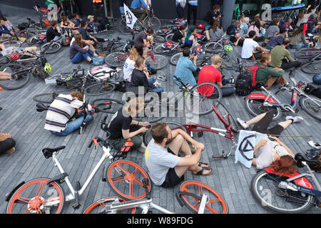 Londra, Regno Unito. Il 18 luglio 2019. Gli attivisti di estinzione ribellione o XR, tenere una massa die-in di fronte al Municipio, il quartier generale del gruppo di Londra della Greater London Authority, lungo il fiume Tamigi vicino al Tower Bridge, impegnative per azione su una verde e più equa di Londra e facendo voto di trattenere un quinto della loro Londra tassa del Consiglio che dovrà pagare in una ribellione fiscali Fondo per raggiungere la neutralità di carbonio entro il 2025. Credito: Joe Kuis / Alamy News Foto Stock