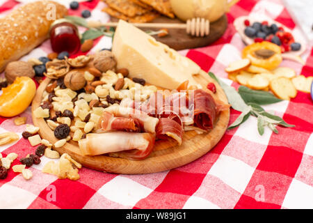 Elegante pic nic sul prato verde. Cornetti freschi e una teiera con il tè su un copriletto vicino a una femmina di vimini hat. Instagram contenuto. Foto Stock