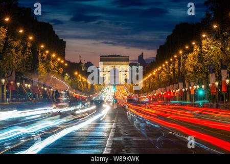 Notte scence illuminazioni di strada di traffico della impressionante Arc de Triomphe Paris lungo il famoso viale alberato viale Avenue des Champs Elysees di Parigi, Fran Foto Stock