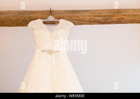 Abito da sposa appendere sul trave in legno Foto Stock