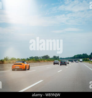 Baden, Germania - Luglio 7, 2019: vista posteriore di nuova rapida orange Porsche 911 auto sportiva su autostrada tedesca - immagine quadrata Foto Stock