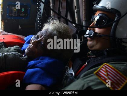 Navy la ricerca e il salvataggio del nuotatore Petty Officer 1. Classe Scott Chun si blocca su un evacuee tirato da un tetto in New Orleans, in Louisiana, come suo SH-60B Seahawk elicottero teste per la zona di atterraggio sul Sett. 5, 2005. Dipartimento della Difesa le unità sono mobilitati come parte della Joint Task Force Katrina per supportare la Federal Emergency Management Agency di disaster relief sforzi in Costa del Golfo luoghi devastati dall' uragano Katrina. Foto Stock