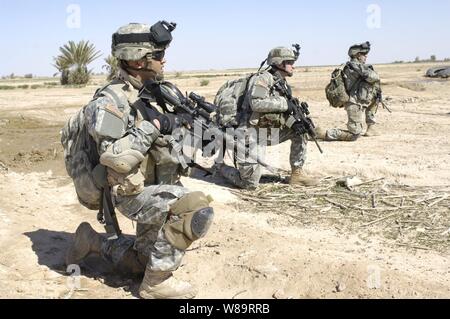 Stati Uniti I soldati dell esercito per prendersi una pausa durante il loro avanzamento attraverso un campo durante il funzionamento Swarmer nel Salah Ad Din provincia dell'Iraq il 16 marzo 2006. Operazione Swarmer è un combinato di air assault operazione per cancellare la zona nord-est di Samarra di presunti insorti. I soldati sono dal Armyís 3° Battaglione, 187th reggimento di fanteria. Foto Stock