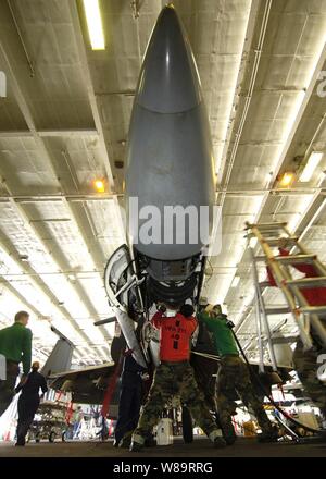 Velisti assegnati a Strike Fighter Squadron 211 eseguire una manutenzione programmata sul 20mm mitragliatrice nella fusoliera di un F/A-18F Super Hornet aerei nella baia di hangar della portaerei USS Enterprise (CVN 65) il 7 marzo 2006. Enterprise e la sua avviato Carrier aria Wing 1 stanno svolgendo una formazione composita dell'unità esercizio mentre in corso nell'Oceano Atlantico. Foto Stock