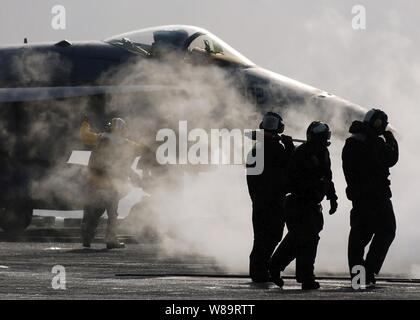 Ponte di volo equipaggi sono avvolti da vapore come essi pronto un F/A-18F Super Hornet aircraft per una catapulta lancio dalla portaerei USS Abraham Lincoln (CVN-72) come la nave opera nel Mare del Giappone il 30 marzo 2006. Il Super Hornet è attaccato a Strike Fighter Squadron 151. Foto Stock