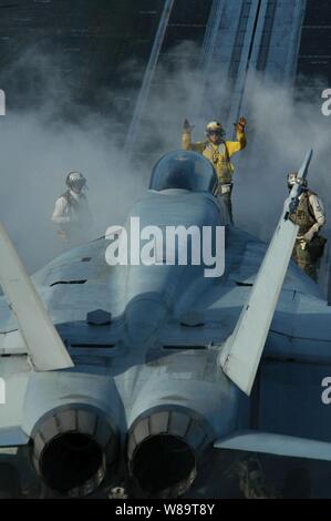 Un U.S. Navy direttore guida il pilota di un F/A-18E Super Hornet aeromobili per la catapulta per lanciare off il ponte di volo della USS Kitty Hawk (CV 63) come la nave opera nell'Oceano Pacifico il 23 giugno 2006. Il Kitty Hawk Carrier Strike Group partecipa in esercizio Valiant scudo 2006, un esercizio congiunto costituito da 28 unità navali, più di 300 aerei, e circa 20.000 membri di servizio dalla Marina, Esercito, Air Force, Marine Corps e Guardia Costiera. Foto Stock