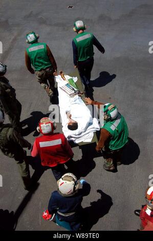 Stati Uniti I marinai della marina trasportare un paziente a un MH-60S Knighthawk elicottero sul ponte di volo della nave ospedale USNS misericordia (T-AH 19) Il 29 agosto 2006. La misericordia è ancorata al largo della costa di Dili, Timor Est, mentre il suo equipaggio conduce umanitari e civico di missioni di assistenza come parte di un cinque mesi di distribuzione a sud e sud-est asiatico e nelle isole del Pacifico. Foto Stock