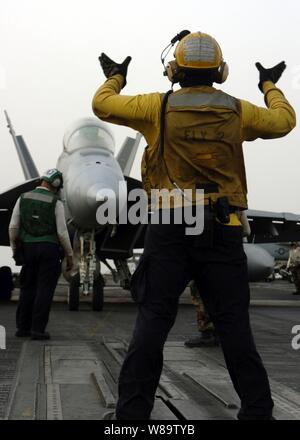 Un U.S. Navy piano direttore guida una F/A-18E Super Hornet aeromobile in posizione di lancio sul ponte di volo della USS Dwight D. Eisenhower CVN (69) il 14 aprile 2007. La Eisenhower e avviato Carrier aria Wing 7 sono sulla distribuzione a sostegno di le operazioni di sicurezza marittima nel Golfo Arabico. Foto Stock