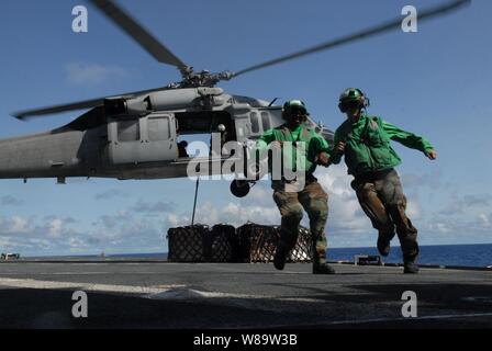 Stati Uniti Aviazione Navale da elettricista, Mate 2a classe Devon Liss (destra) e Aviation Electronics tecnico di prima classe marrone McKinnley assegnato per la USNS Ponte (T-AOE 10) eseguire chiara dal ponte di volo come un MH-60S Knighthawk elicottero preleva i pallet di alimentazione durante un rifornimento in mare con la USS John C. Stennis CVN (74) in corso nell'Oceano Pacifico sulla il 6 agosto 2007. I rifornimenti sono condotte regolarmente all'approvvigionamento di navi con cibo, pezzi di ricambio e carburante. Foto Stock