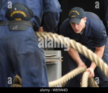 Stati Uniti Navy Airman apprendista Matthew Watson fake giù le linee di ormeggio come la Nimitz-class portaerei USS Abraham Lincoln (CVN 72) si prepara a cominciare dal suo porto stazione navale Everett, Washington, sul Sett. 18, 2007. Il Lincoln partì per la sostituzione della flotta squadrone qualifiche portante. Foto Stock