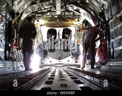 Stati Uniti I marinai della marina militare fuori carico una carena rigida gommone dall'interno di un C-130 Hercules aeromobili a Ali Al Salem Air Base, Kuwait, il 6 gennaio 2008. I marinai sono attaccati al comandante, Task Force 53. Foto Stock