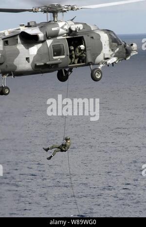 Un U.S. Navy l'eliminazione degli ordigni esplosivi tecnico respinge da un HH-60H Sea Hawk elicottero sul ponte di volo della portaerei USS Nimitz CVN (68) durante una routine di esercizio di formazione mentre in corso nel Mar Cinese orientale il 15 marzo 2008. Il tecnico è assegnato per l'eliminazione degli ordigni esplosivi unità mobile 11. Foto Stock