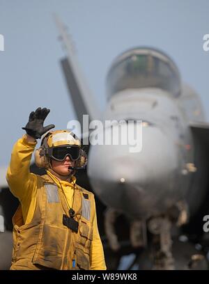 Un U.S. Navy direttore segnali ad un conducente del trattore durante le operazioni di volo a bordo della Nimitz-class portaerei USS Abraham Lincoln (CVN 72) mentre è in corso nel Golfo Persico, il 13 maggio 2008. La Lincoln è distribuito negli Stati Uniti Navy Quinta Flotta area di responsabilità per supportare le operazioni di sicurezza marittima. Foto Stock