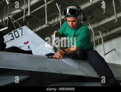 Stati Uniti Aviazione Navale meccanico strutturale Louis Velarde grassi il bordo di entrata della trasmissione dello sportellino di un F/A-18C Hornet a bordo della Nimitz-class portaerei USS Abraham Lincoln (CVN 72) nel Golfo Arabico il 7 maggio 2008. La Lincoln è distribuito negli Stati Uniti Navy Quinta Flotta area di responsabilità per supportare le operazioni di sicurezza marittima che promuovere la stabilità. Foto Stock