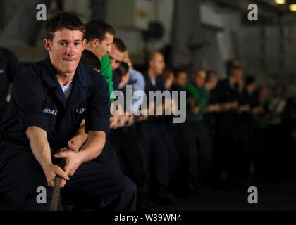 Stati Uniti Navy Seaman Buck Bromley e altri marinai heave una linea di messenger a bordo della Nimitz-class portaerei USS Abraham Lincoln (CVN 72) durante un rifornimento in corso con il combattimento veloce nave appoggio USNS Rainer (T-AOE 7) mentre nel Golfo Persico il 22 maggio 2008. La Lincoln è dispiegato per la Quinta Flotta area di responsabilità per supportare le operazioni di sicurezza marittima. Foto Stock