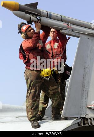 Stati Uniti Navy Petty Officer di terza classe Zachary Sonson di Strike Fighter Squadron 87 attribuisce un filo elettrico ad un inerte formazione missile caricato su di un F/A-18 Hornet aeromobile a bordo della USS Theodore Roosevelt (CVN 71) nel Golfo di Oman su Ott. 15, 2008. Foto Stock