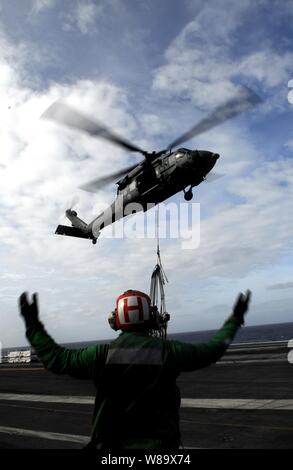 Stati Uniti Navy Petty Officer di terza classe Marcus J. McElroy dirige un MH-60S Sea Hawk elicottero da combattimento del mare Squadron 8 sopra il ponte di volo della portaerei USS John C. Stennis (CVN 74) durante un rifornimento verticale operazione con la USNS Kiska (T-AE 35) nell'Oceano Pacifico nel Febbraio 7, 2009. La Stennis e Carrier aria Wing 9 sono su sei mesi di distribuzione per il Pacifico occidentale. Foto Stock