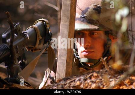 Stati Uniti Navy Petty Officer 1. Classe Dennis Tadlock, assegnato alla Naval Mobile Battaglione di costruzione 1, veglia del camp perimetro da una posizione di combattimento a Camp Shelby, Miss., il 10 marzo 2009. Più di 200 Seabees, la maggior parte dei nuovi per il battaglione, partecipano al funzionamento inverno Taloni, un campo di esercizio che metterà alla prova la loro lotta e costruzione di contingenza capacità in un ambiente di campo. Foto Stock