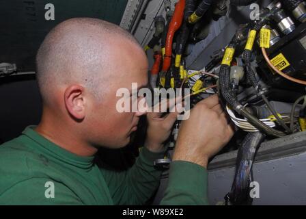 Stati Uniti Navy Petty Officer di terza classe Ryan Clogston sostituisce un impulso del decodificatore su una F/A-18C Hornet aeromobile da Strike Fighter Squadron 146 nella baia di hangar della portaerei USS John C. Stennis CVN (74) in corso nell'Oceano Pacifico il 5 maggio 2009. Un decodificatore di impulsi è un componente del velivolo di automazione del gestore di sistema di atterraggio. La nave e il Carrier aria Wing 9 sono su sei mesi di distribuzione nell'Oceano Pacifico occidentale. Foto Stock