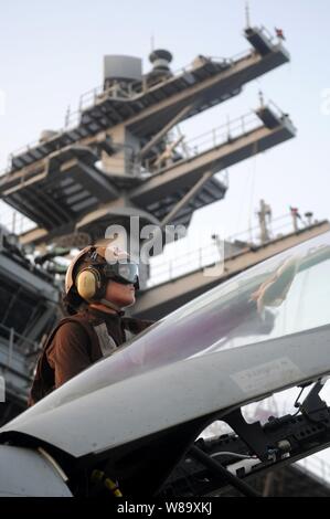 Stati Uniti Navy Petty Officer di terza classe Courtney poteri, un piano capitano, pulisce la tettoia di un F/A-18E Super Hornet, assegnato a Strike Fighter Squadron 115, sul ponte di volo della portaerei USS Ronald Reagan (CVN 76) nel Mar Arabico il 7 luglio 2009. Il Piano I comandanti sono arruolati marinai che sono responsabili di un aircraftís manutenzione e la manutenzione. La Ronald Reagan è distribuito negli Stati Uniti Quinta Flotta area di operazioni. Foto Stock